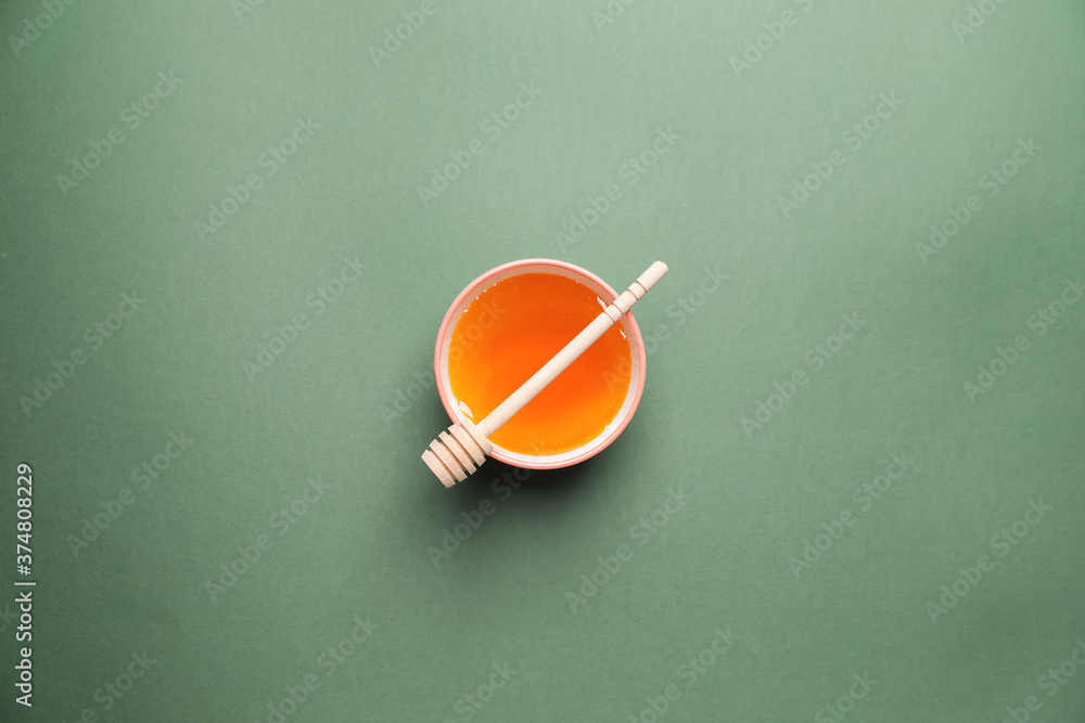 Bowl with honey on color background