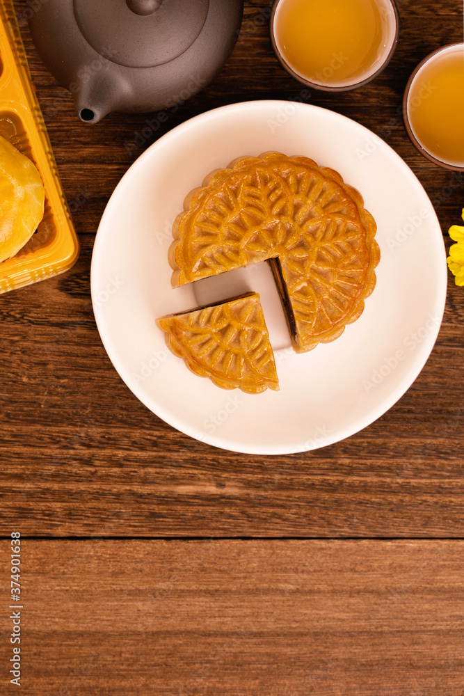 中秋节月饼，美味漂亮的新鲜月饼，放在深色木巴上的盘子里