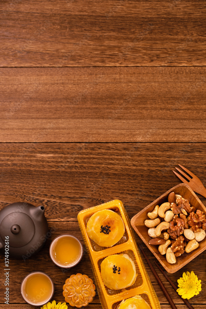 Moon cake for Mid-Autumn Festival, delicious beautiful fresh mooncake on a plate over dark wooden ba