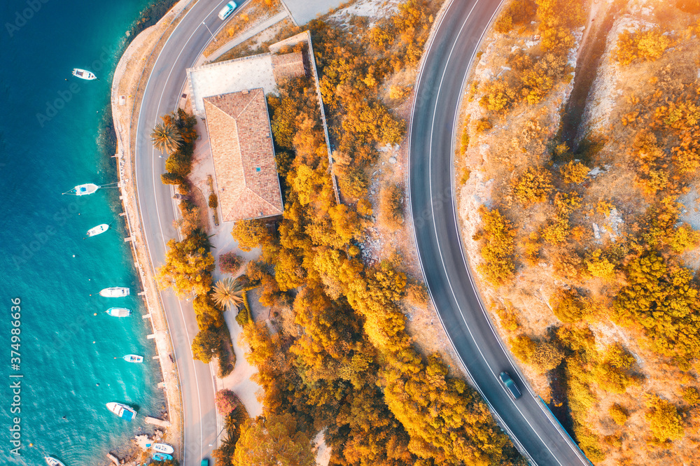 鸟瞰道路，水中的船只和游艇，秋天日落时的建筑。五颜六色的风景wi