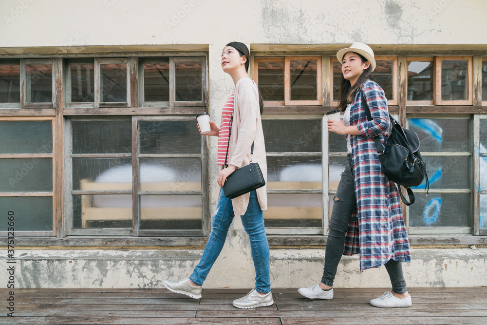 年轻的亚洲女性在老城区漫步。两个时尚的女孩朋友玩得很开心