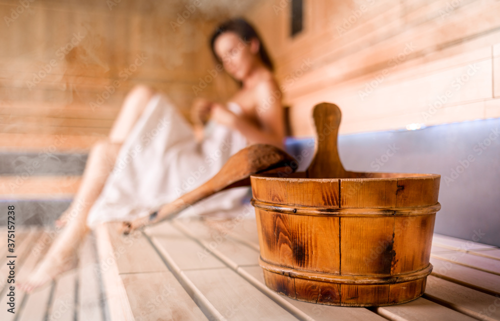 Beautiful young woman relaxing in Finnish sauna