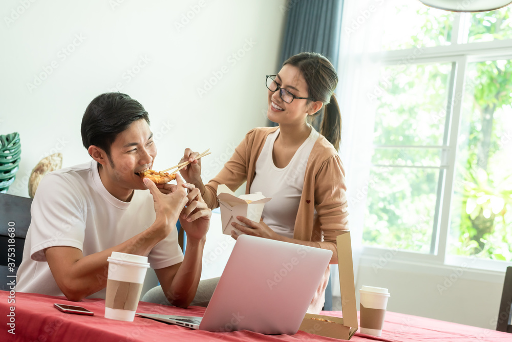 Asian couple having lunch at home by order delivery food