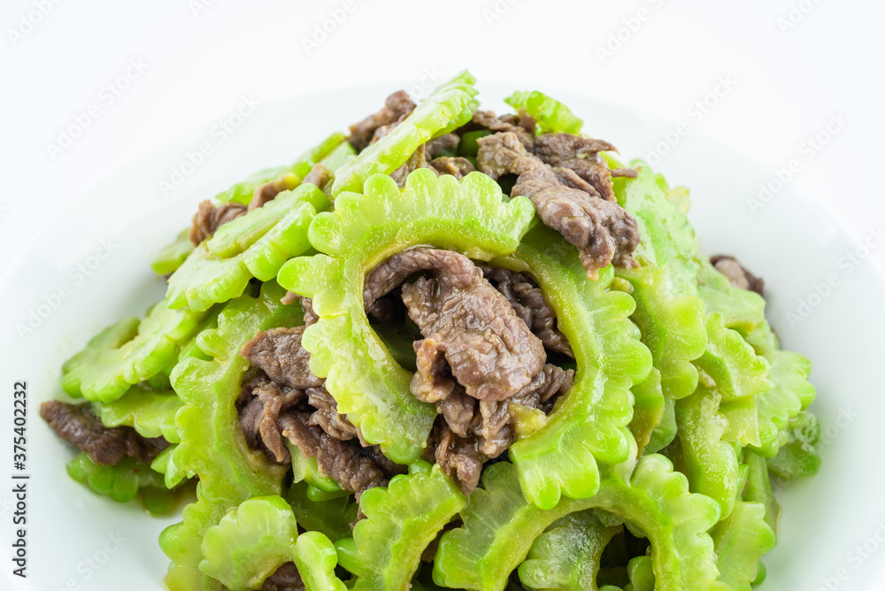 Stir-fried beef with bitter gourd on a plate on white background