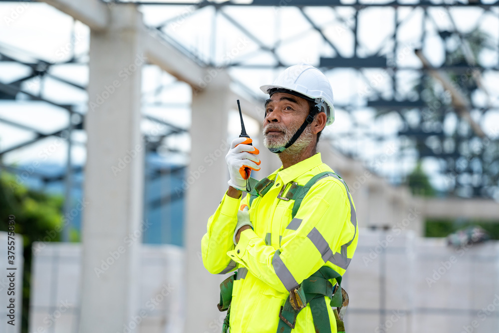 Engineer using radio communication on building site,Engineer use walkie talkie for work.