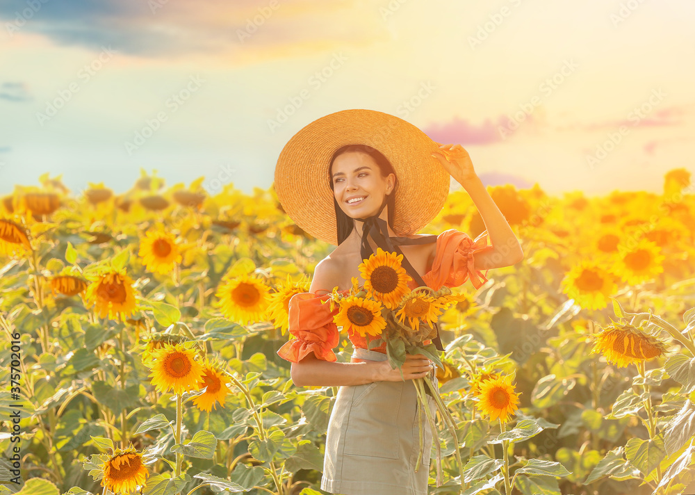 Beautiful young woman in sunflower field on sunny day