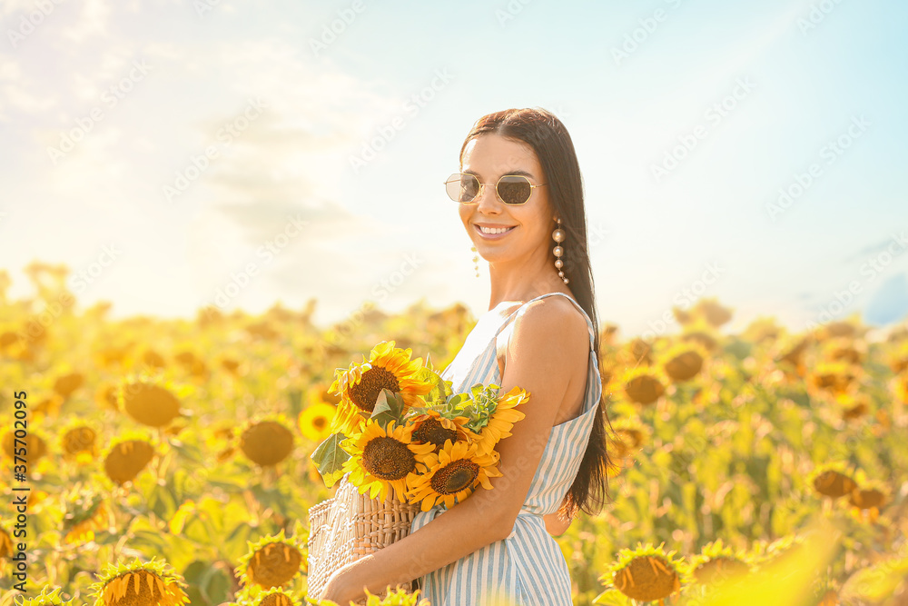 阳光明媚的向日葵地里美丽的年轻女子