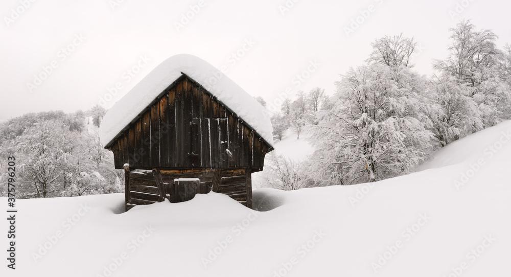 雪山木屋的极简主义冬季景观。多云的天气，景观照片