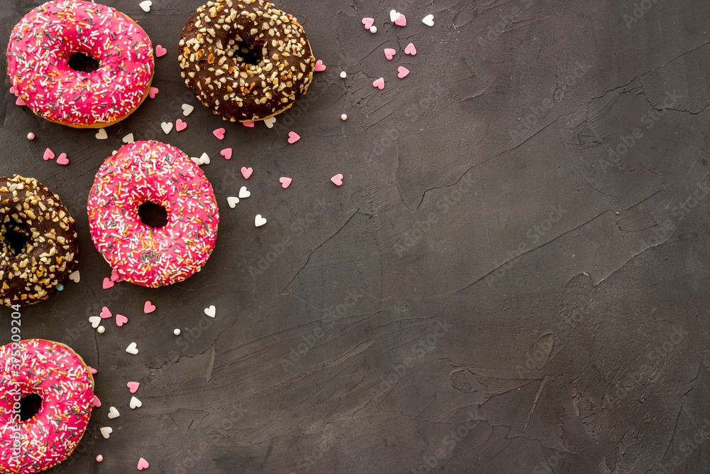 Donuts flat lay pattern on dark background, top view