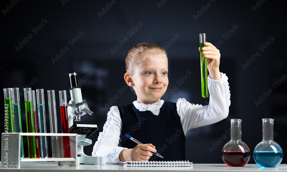 Little girl scientist examining test tube