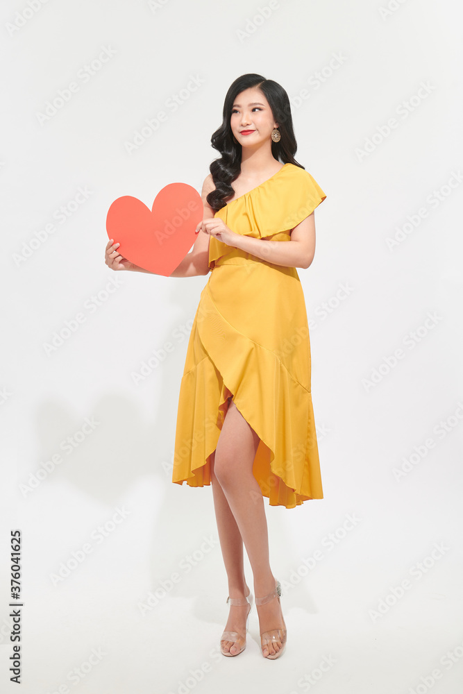 Woman holding big red heart on white background