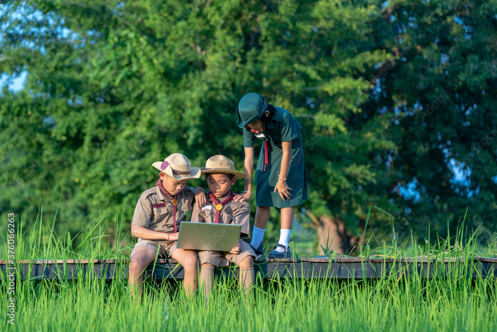 Scouts are using laptop at scout camp.