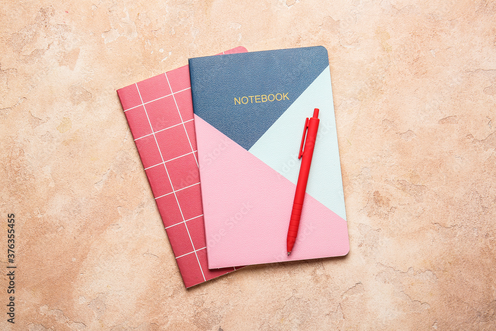 Notebooks and pen on color background