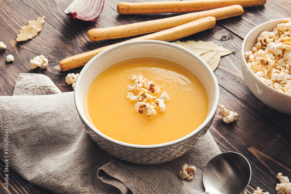 Bowl with tasty popcorn soup on table