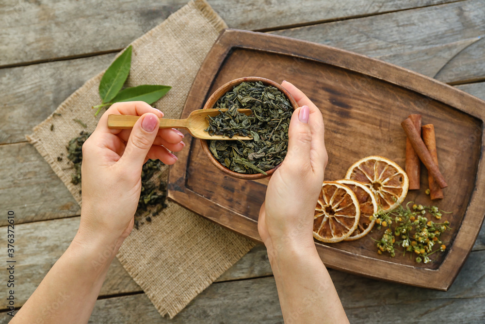 碗里有干茶叶的女性手，俯视图