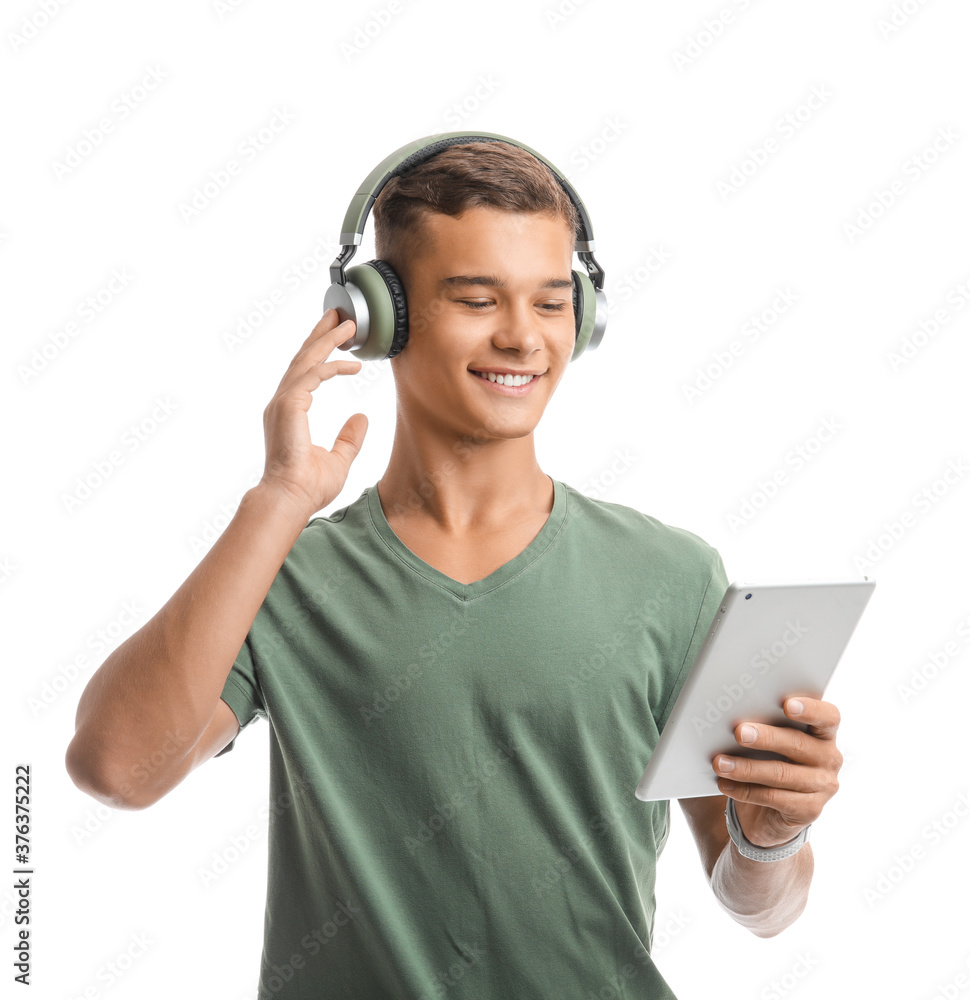 Teenage boy listening to music on white background