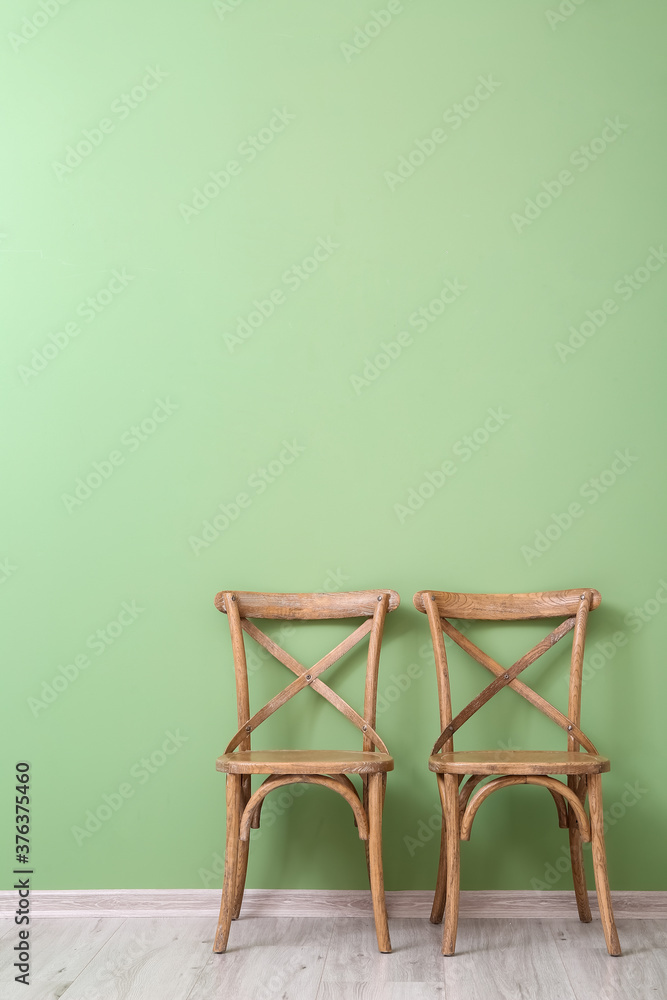 Wooden chairs near color wall