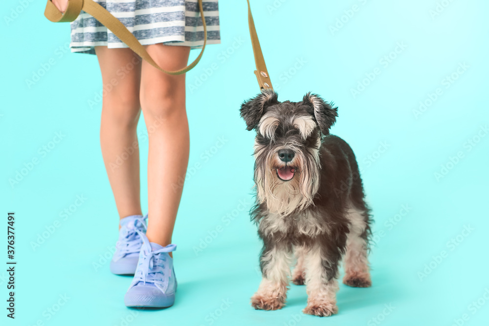 Little girl with cute dog on color background