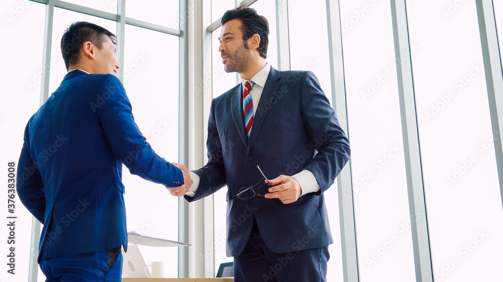 Business people handshake in corporate office showing professional agreement on a financial deal con