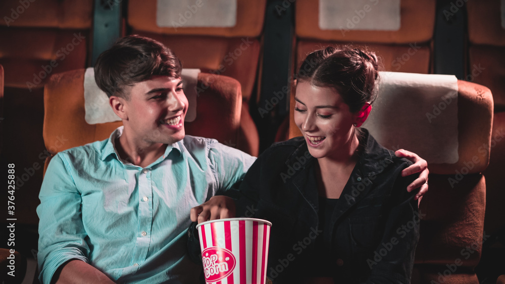 Men and women are eating and tossing popcorn was fun into their mouths in theater