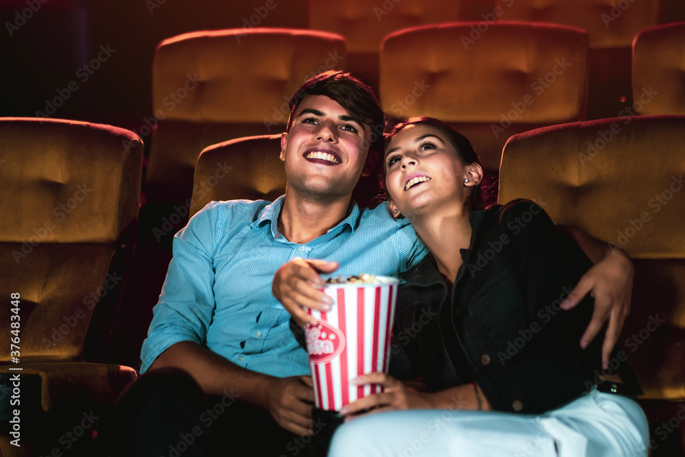 Man and woman watching movie in the movie theater cinema. Group recreation activity and entertainmen