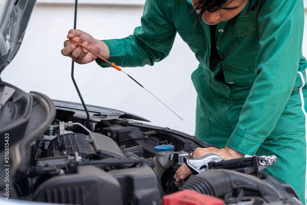 Professional mechanic hand providing car repair and maintenance service in auto garage. Car service 