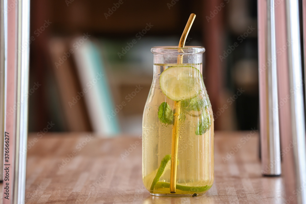 Bottle of tasty cold ice tea on table in room