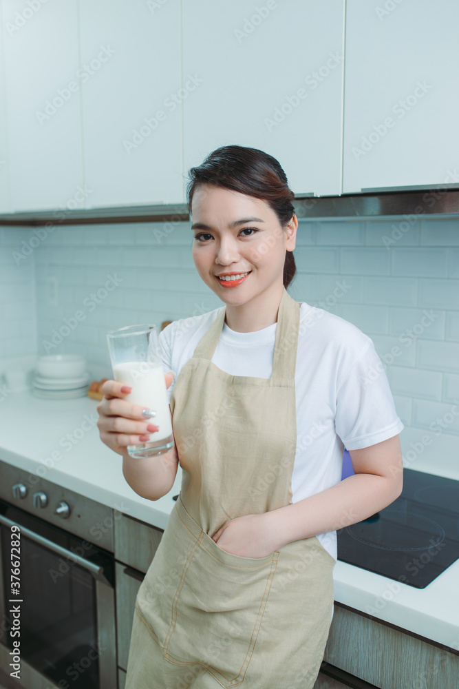 亚洲女人在厨房喝牛奶