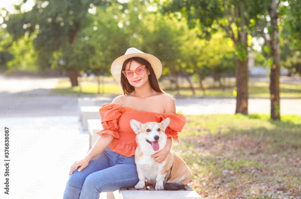 带着可爱的柯基犬在户外散步的女人