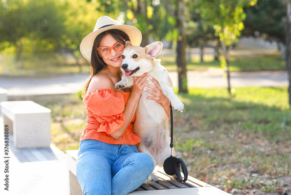 带着可爱的柯基犬在户外散步的女人