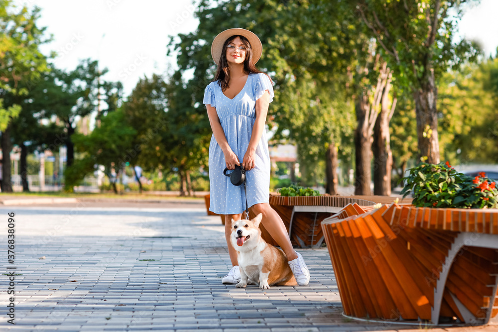 带着可爱的柯基犬在户外散步的女人