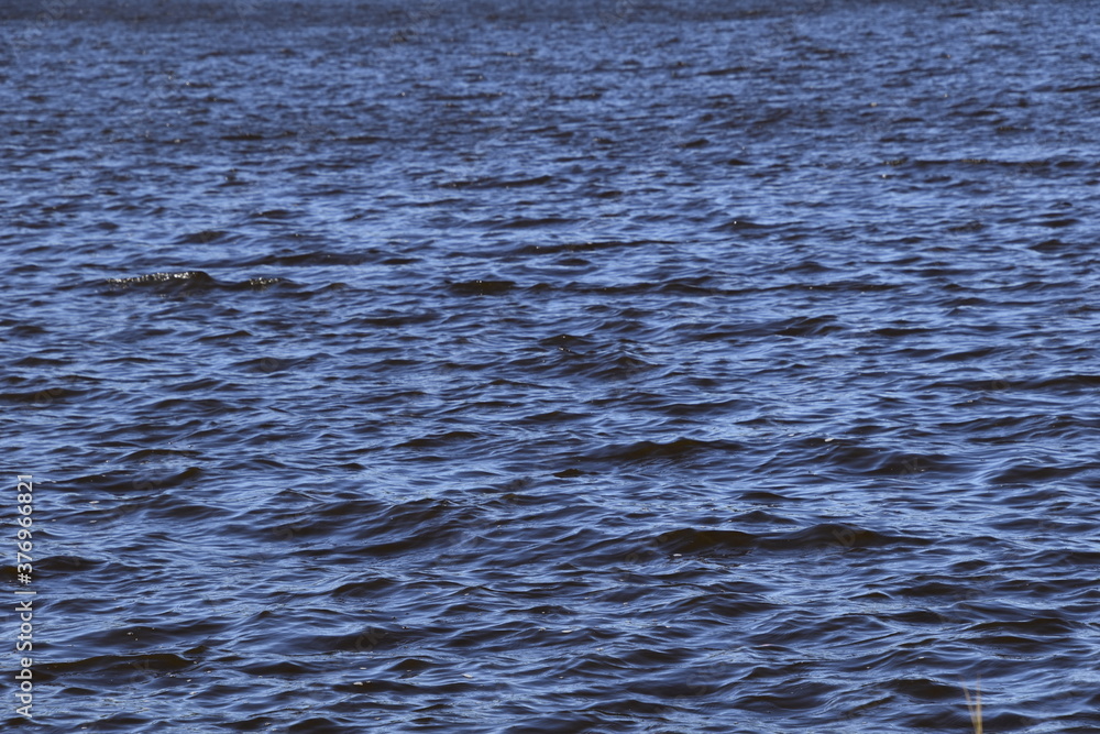 Cold river water with soft waves up close.