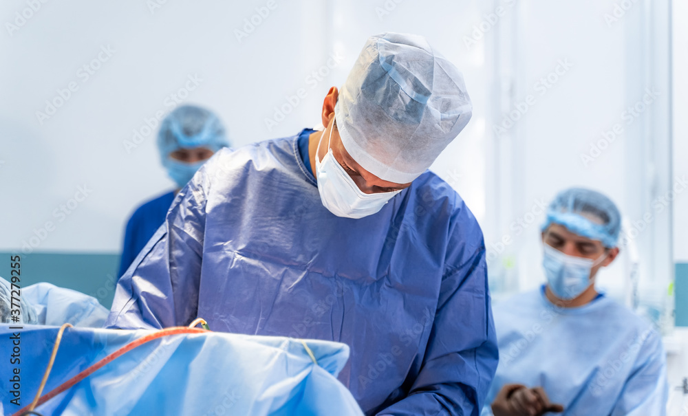 Surgical room in hospital with robotic technology equipment. Machine arm in neurosurgeon`s hands. Cl