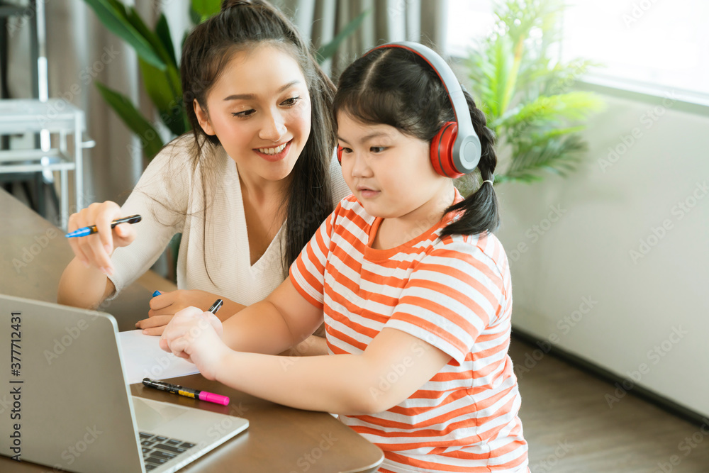 亚洲母亲喜欢在家上学时教孩子和女儿解释家庭作业，以便在线学习