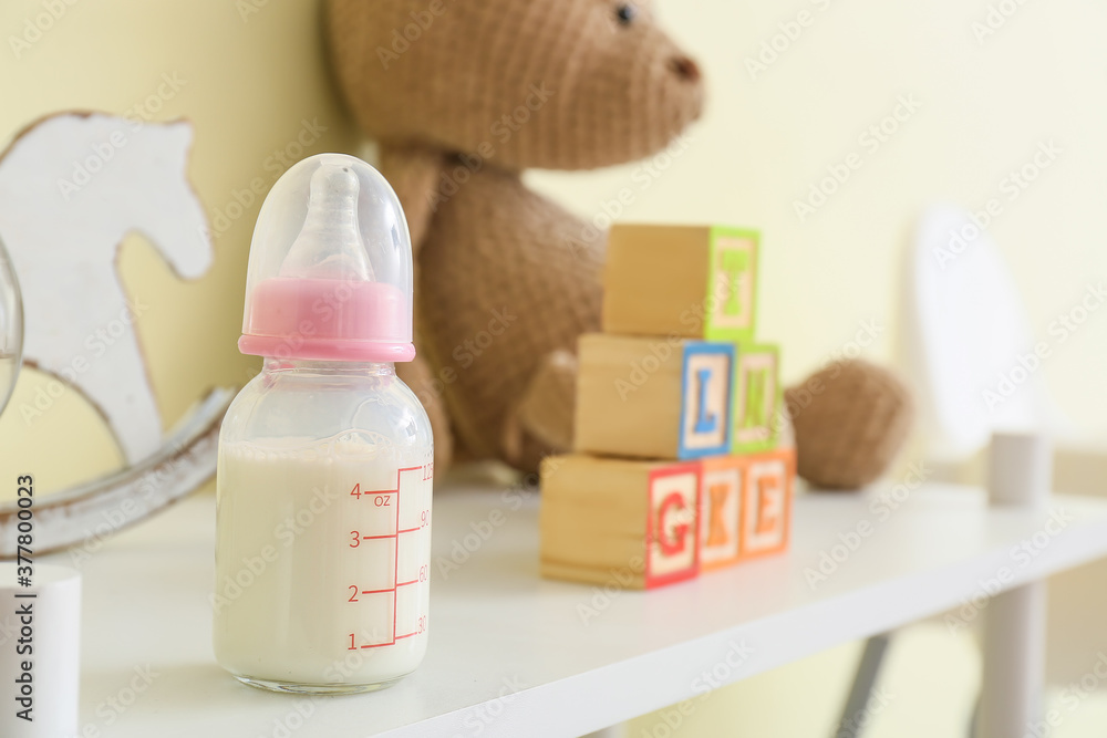 Bottle of milk for baby on table in room