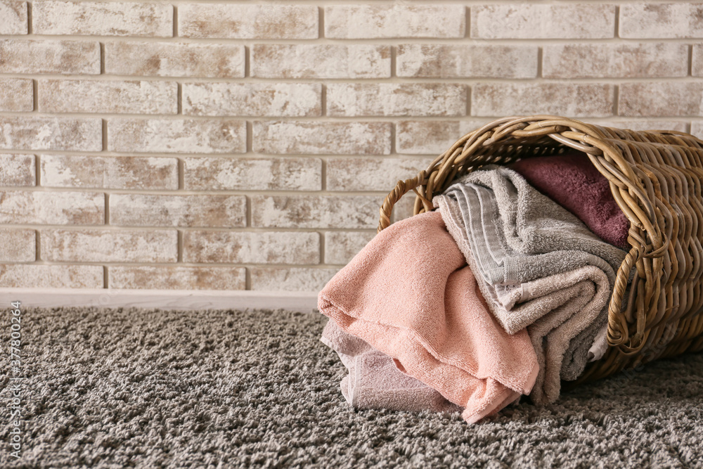 Wicker basket with clean towels in room