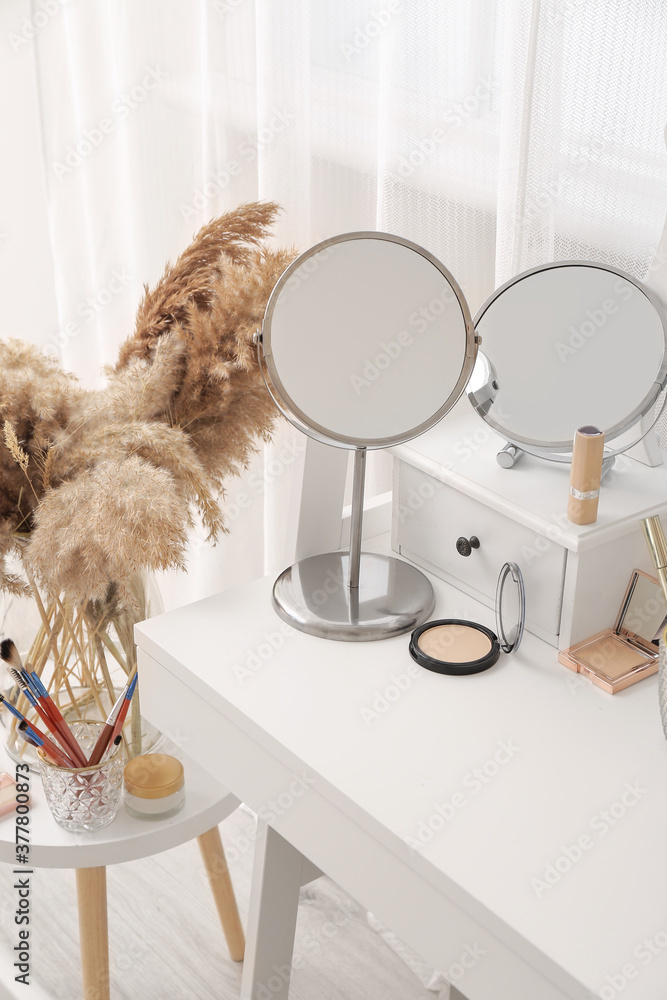 Set of decorative cosmetics and mirrors on dressing table