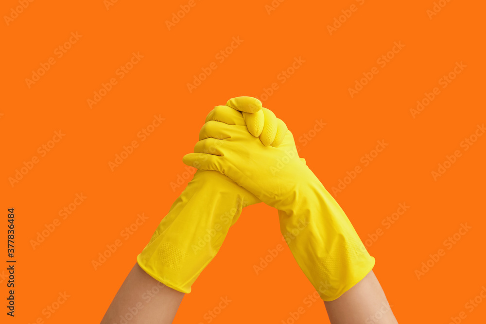 Hands in rubber gloves on color background