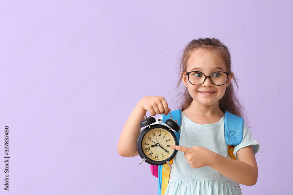 彩色背景上有闹钟的小女生。该学习了