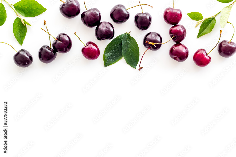 Layout of sweet cherries with leaves, top view, copy space