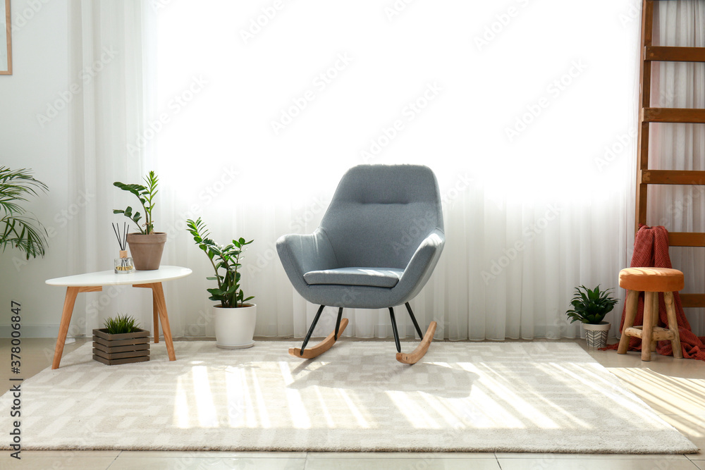 Interior of room with stylish armchair and houseplants