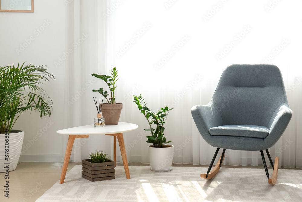 Interior of room with stylish armchair and houseplants