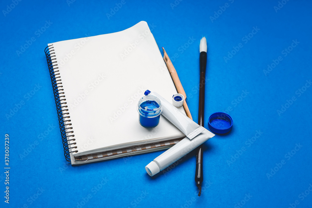 Supplies for calligraphy practice on color background