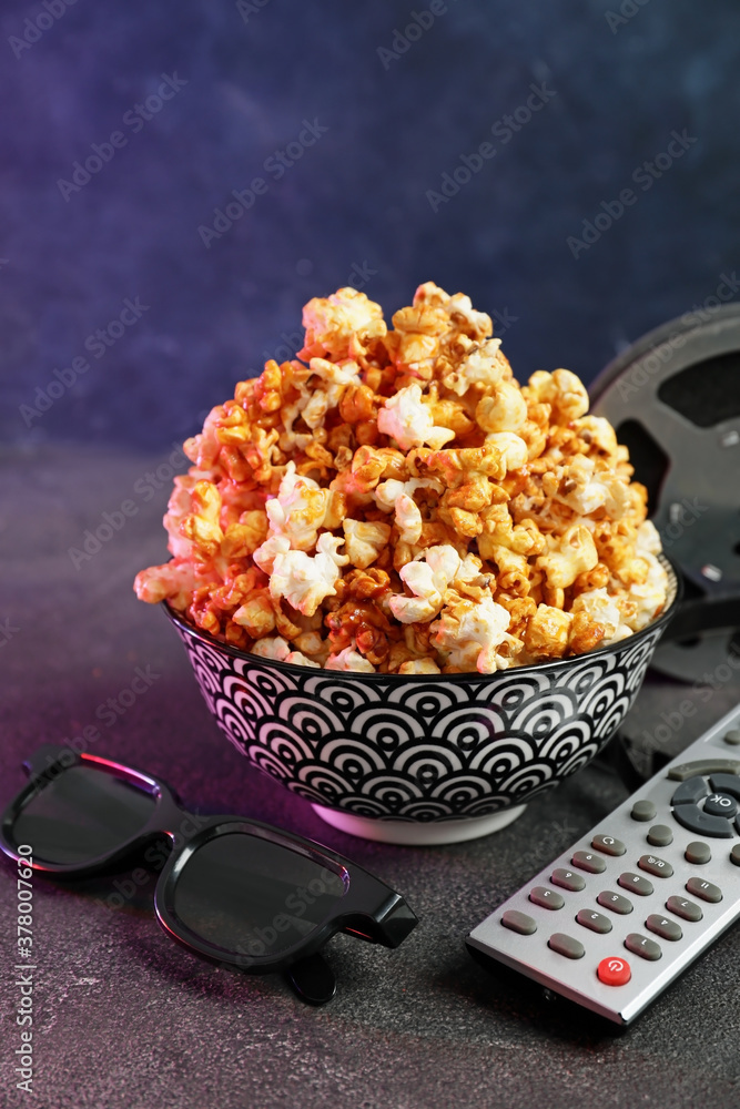 Popcorn, 3D glasses and remote control on dark background