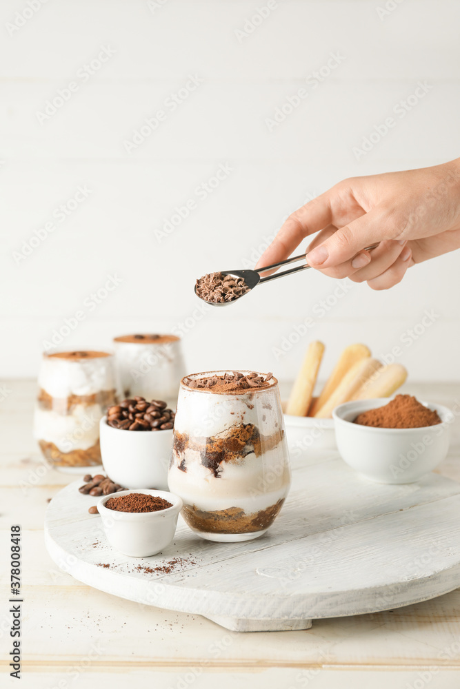 Woman making tasty tiramisu at home