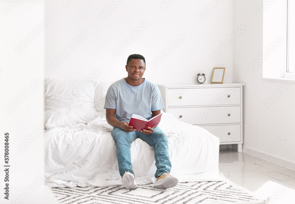 African-American man reading book at home