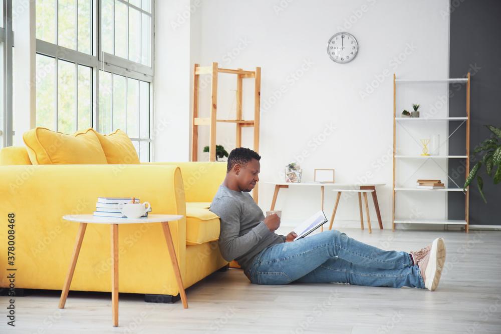 African-American man reading book at home