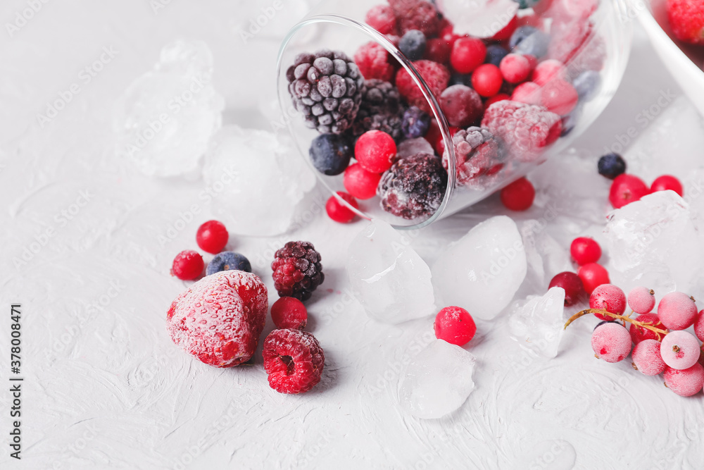 Overturned glass with frozen berries on table