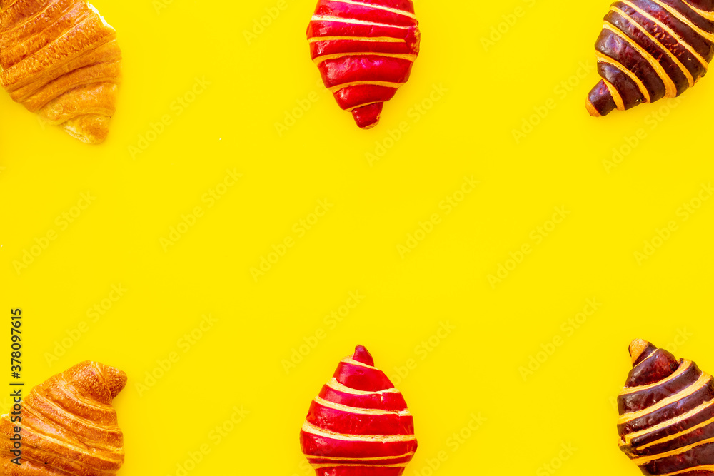 Frame of croissants - fresh bakery on yellow background. Top view