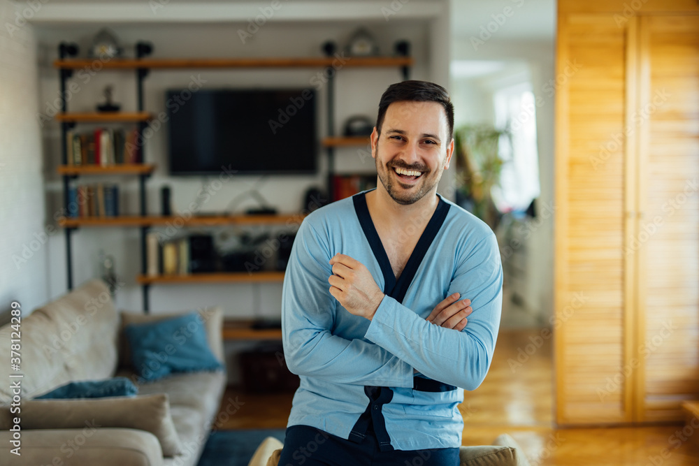 Handsome positive man in pajamas, relaxing at home.